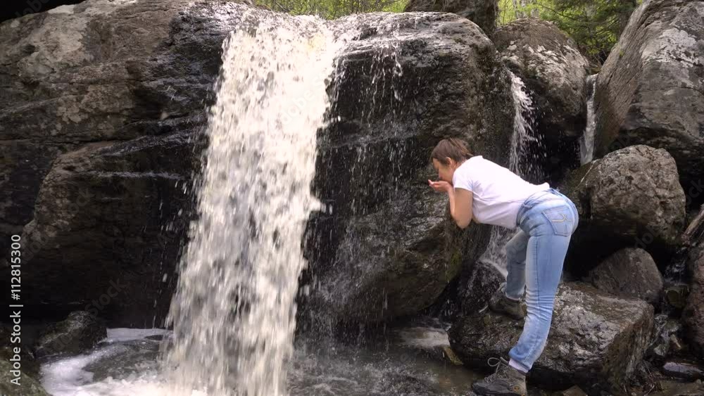 Woman Washes With Clean Water From a Waterfall