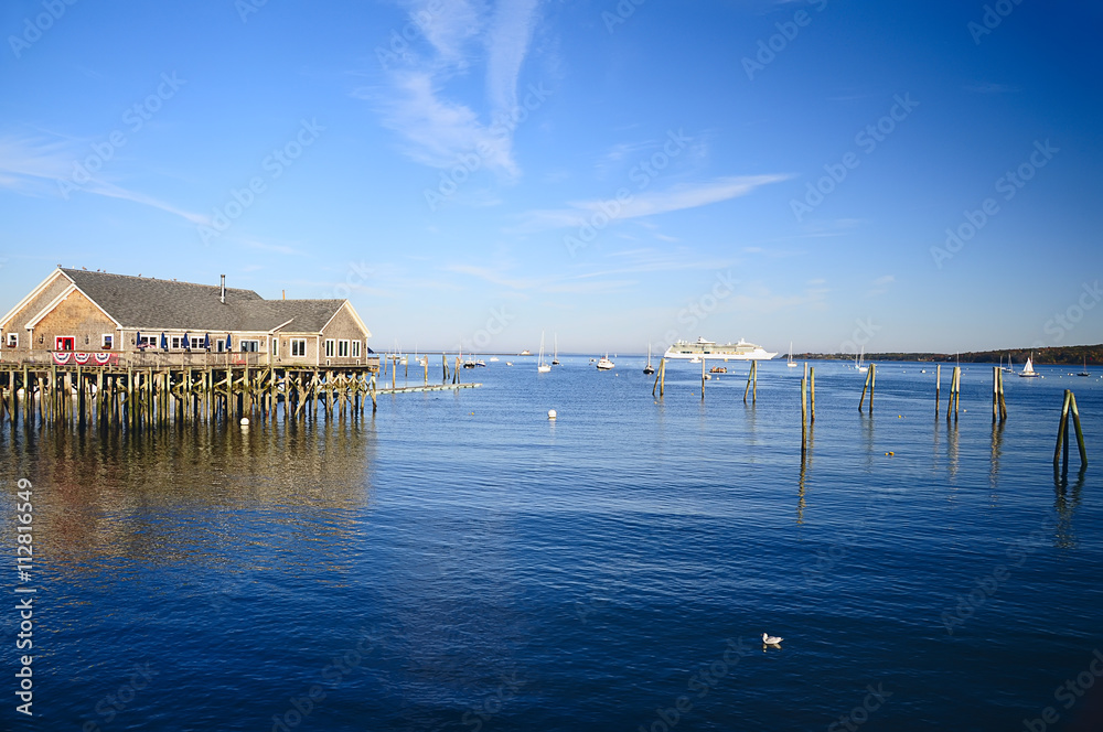 Obraz premium Atlantic Ocean Maine. coastal cafes on stilts in the water, boats at sea. Bay. Sunny day with clear skies. 