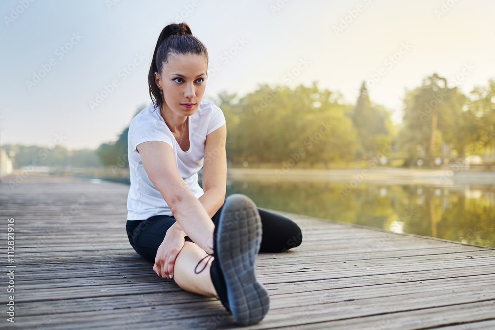 Attractive young woman stretching during morning running rutine.