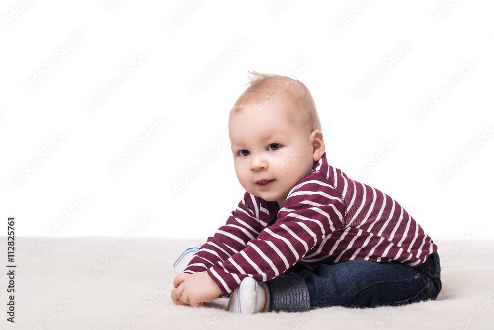 cute baby boy with big hazel eyes sitting on a blanket, smiling and played. child on a white background, isolated. happy family concept cute baby boy with big hazel eyes sitting on a blanket, smiling and played. child on a white background, isolated. happy family concept