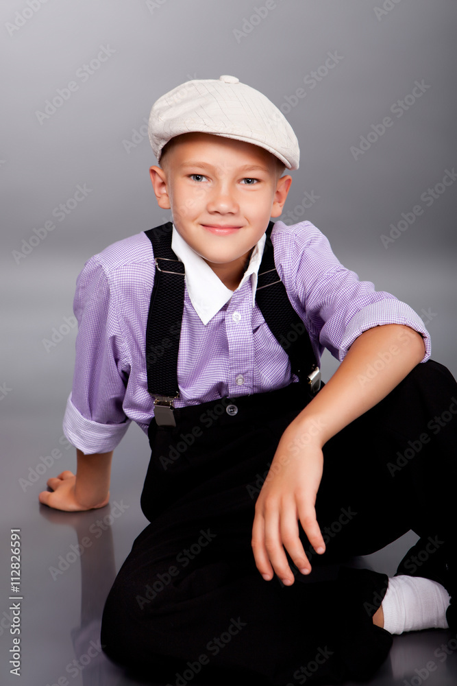 Old fashioned boy sitting on gray background Old fashioned boy sitting on gray background