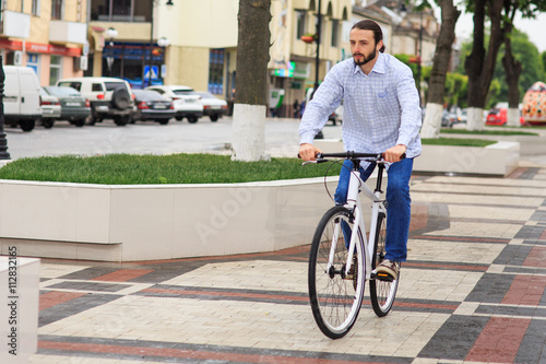 young hipster man with fixed gear bike on city street