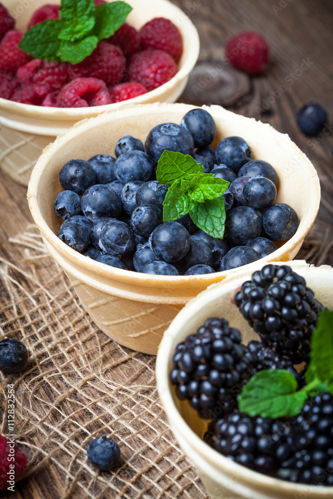 Blackberries, raspberries and blueberries in a waffle bowls.