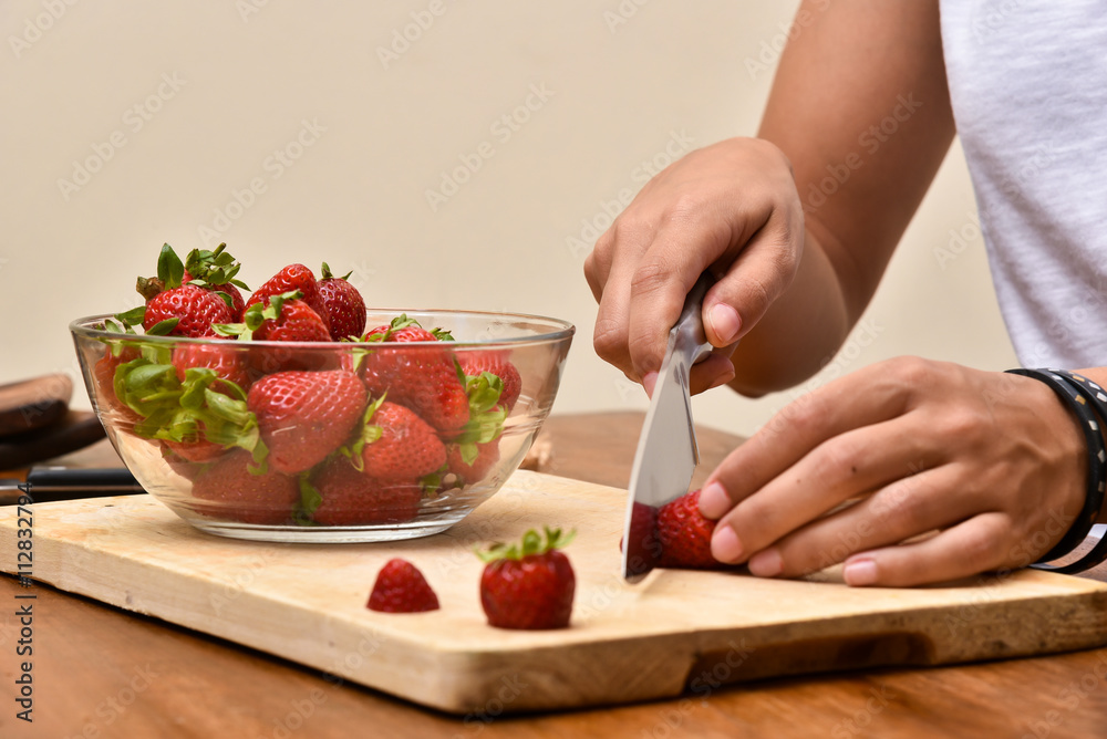 Slicing strawberries on a wooden table
