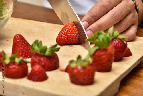 Slicing strawberries on a wooden table