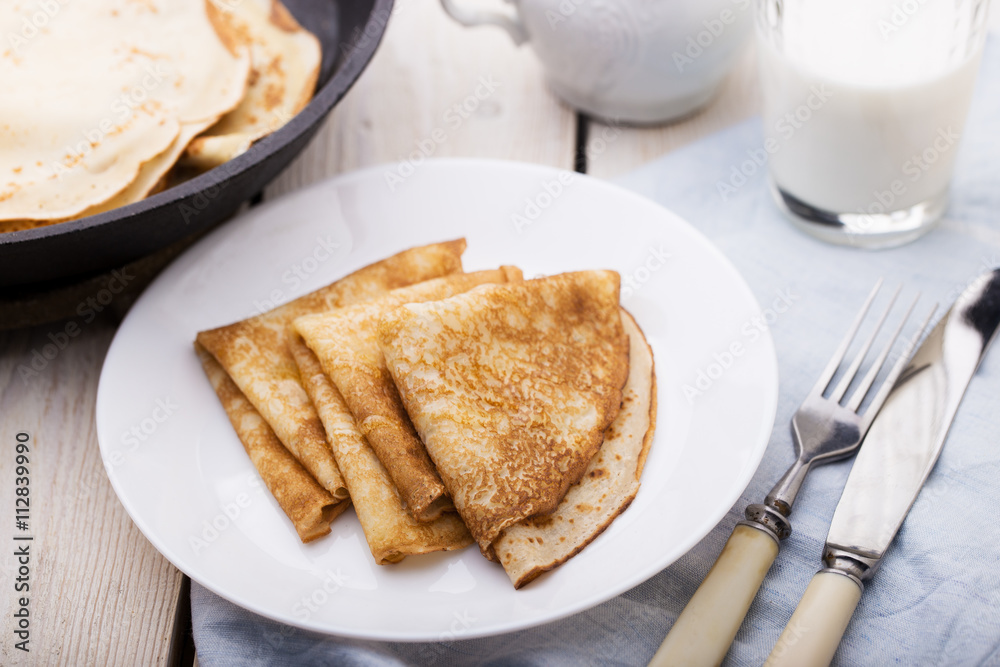 Thin pancakes (crepes) served on white plate Thin pancakes (crepes) served on white plate