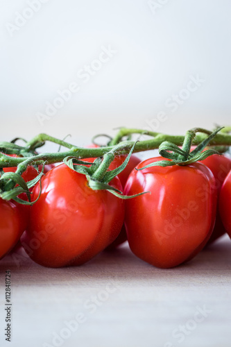 Vertical view of fresh tomatoes on a wooden desk. Macro shot of red tomatoes.