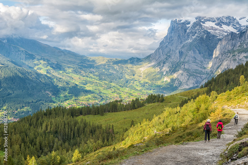 Hikers walking on spectacular mountain scenery in Switzerland