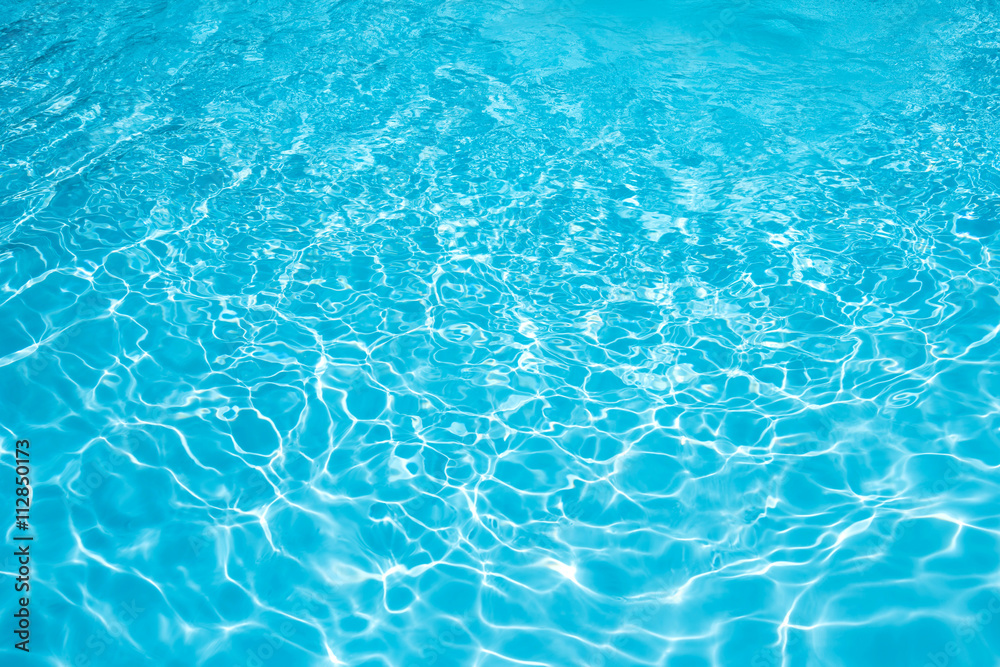 Blue water abstract in swimming pool, water surface with sun reflection in swimming pool