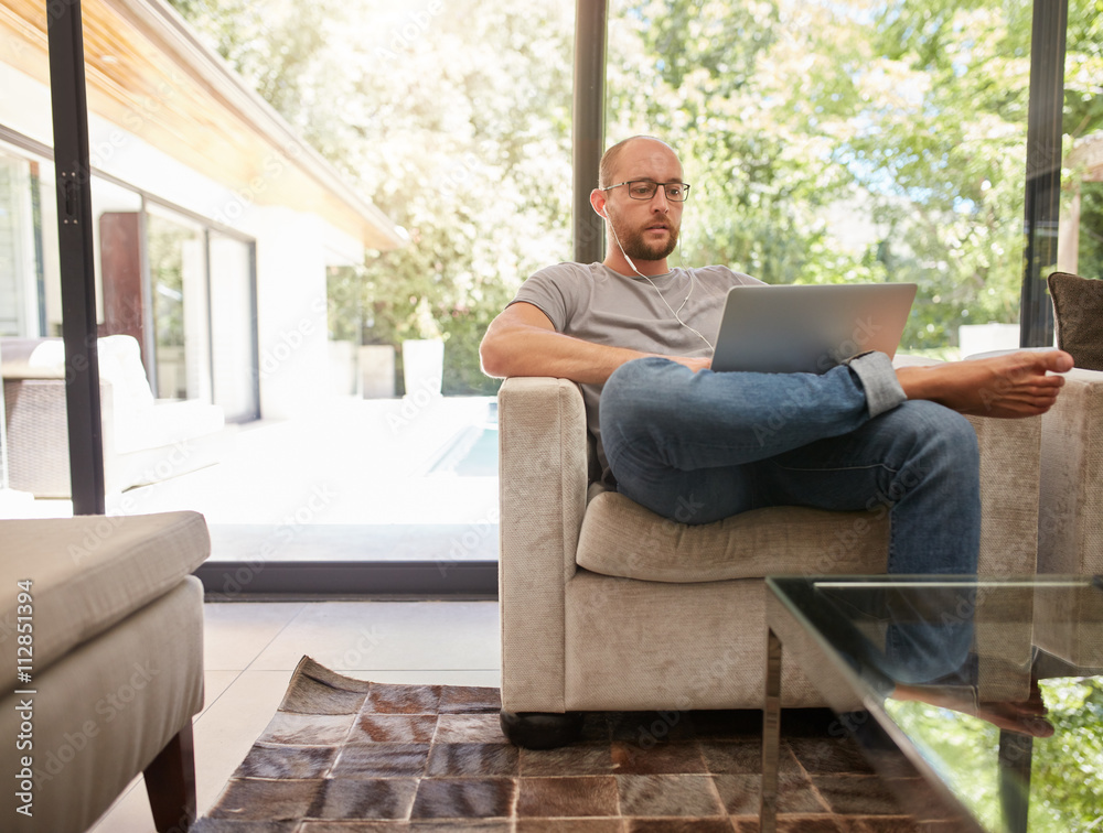 Relaxed man working on laptop at home