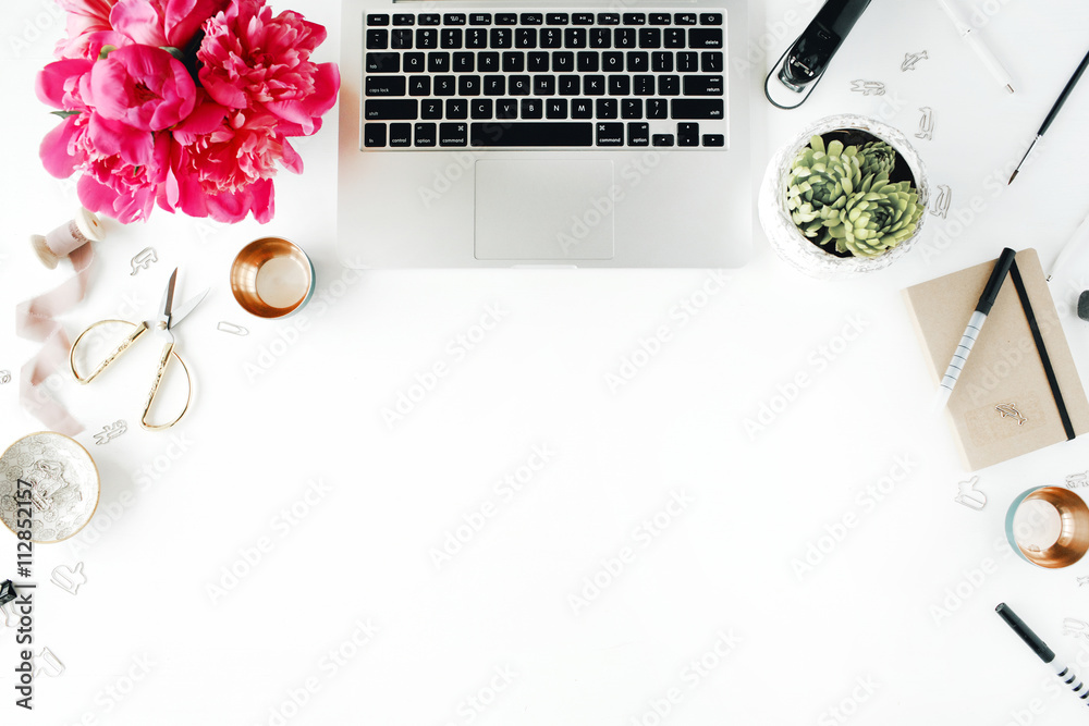Fototapeta premium Workplace with laptop, succulent, peonies, golden scissors, spool with beige ribbon, pencils and diary. Flat lay composition for bloggers, magazines, social media and artists. Top view.