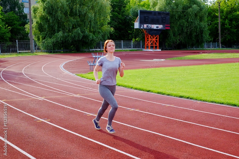 Fototapeta premium Girl runs at the stadium