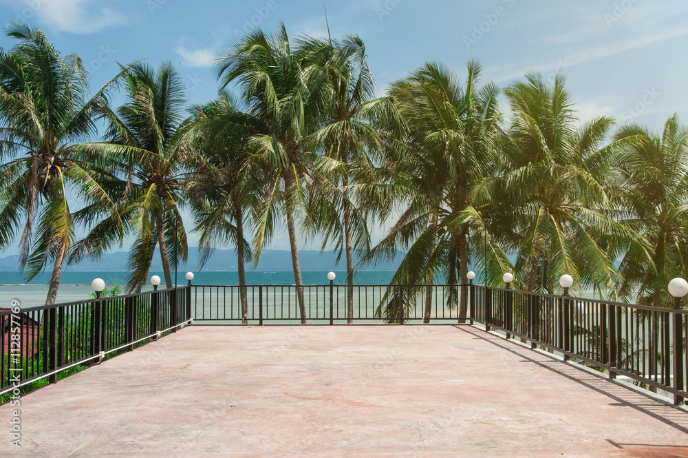 Fototapeta premium concrete platform surrounded by a fence and palm trees