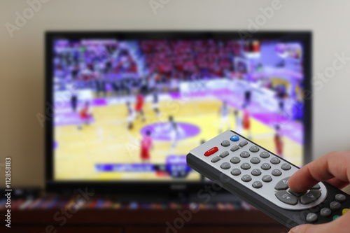 Remote control in the hand, during a basket match