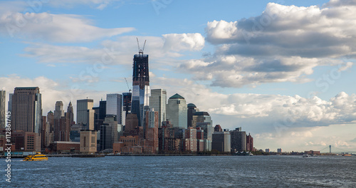Low Angle Architectural View of Modern Glass Skyscrapers Featuring One World Trade Center Building Against Blue Sky  Manhattan