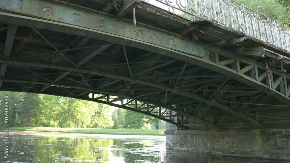 Beautiful historic bridge over the river channel. Swimming the boat through the channel under the bridge. Movement under an ancient bridge, active traveler. Beautiful historic bridge over the river channel. Swimming the boat through the channel under the bridge. Movement under an ancient bridge, active traveler.