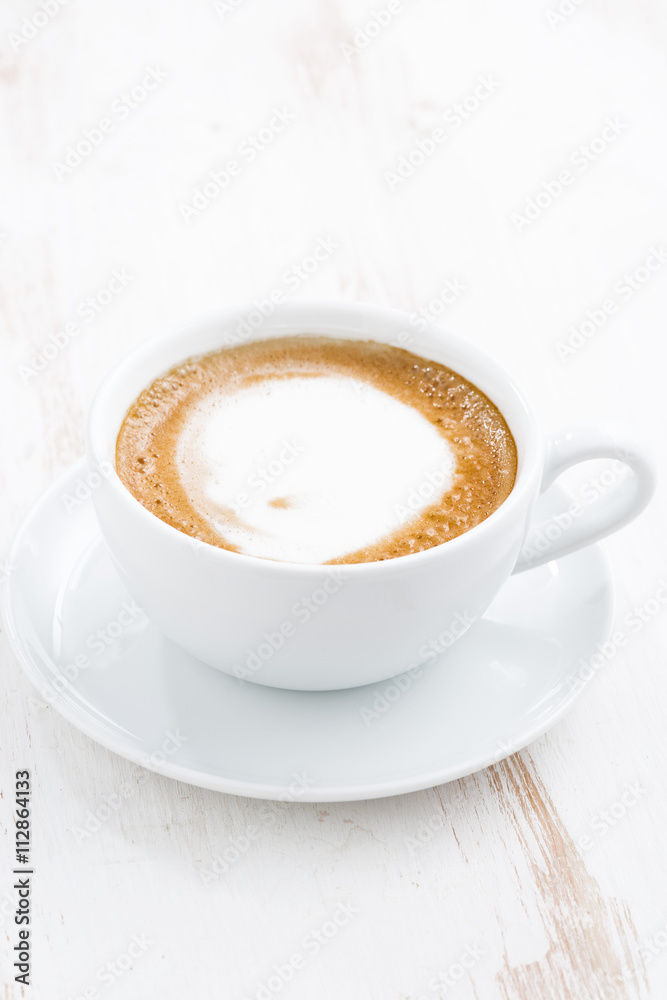 cup of cappuccino on a white wooden table, vertical cup of cappuccino on a white wooden table, vertical