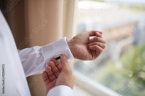 close up of a hand man how wears white shirt and cufflink