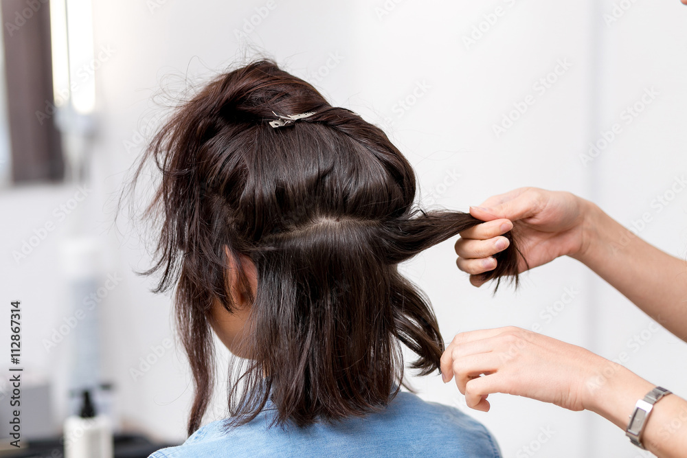 Fototapeta premium stylist hairdresser in barber shop doing haircut closeup of work