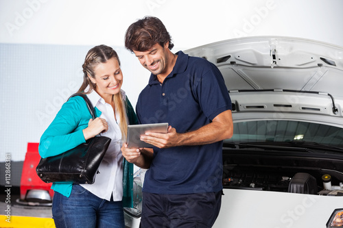 Customer And Technician Using Digital Tablet By Car © Tyler Olson