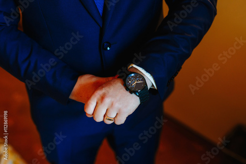 The man in the blue jacket in the window wears a watch
