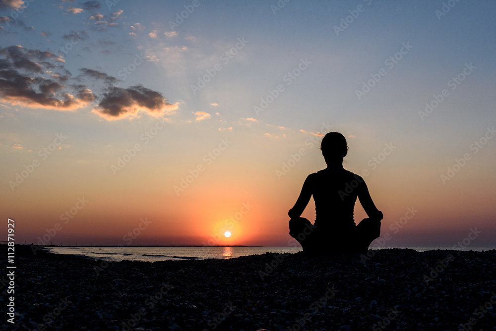 girl on the beach at dawn in yoga assana