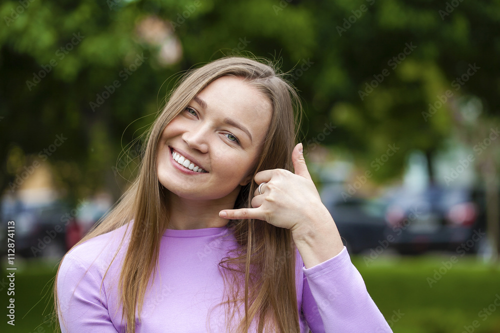 Beautiful woman making a call me gesture Beautiful woman making a call me gesture