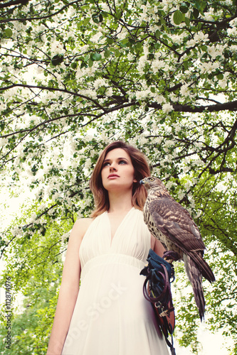 Beautiful Woman with Hawk on Blossom Background photo