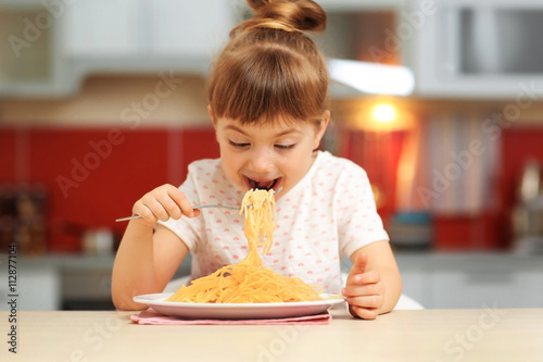 Adorable little girl eating...