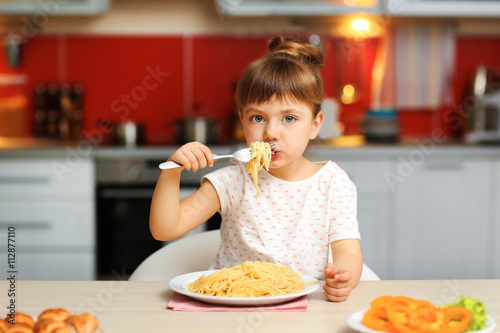 Adorable little girl eating...