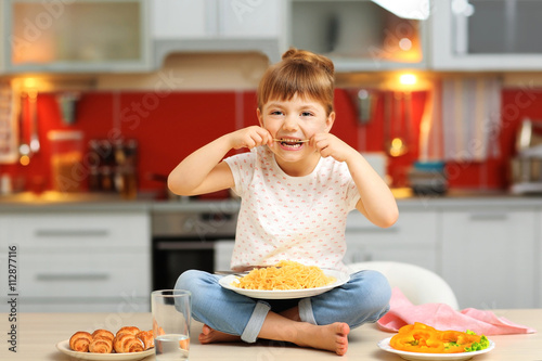 Adorable little girl eating...