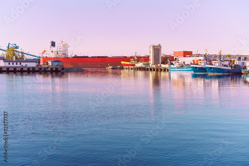 Vessels and cranes at Marina in Ventspils at sundown photo