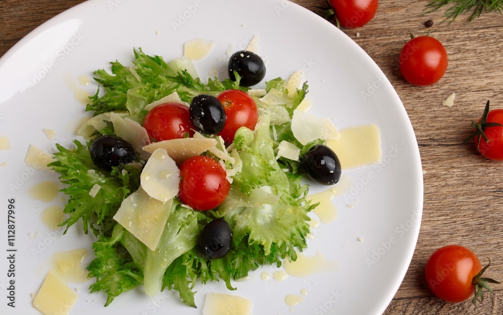 Fresh vegetables salad with tomatoes , olives , parmesan cheese