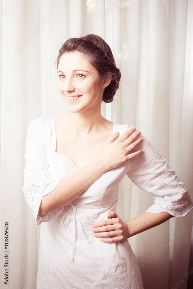portrait of elegant beautiful young lady in white dress happy smiling & looking up on copy space tulle curtain background portrait of elegant beautiful young lady in white dress happy smiling & looking up on copy space tulle curtain background