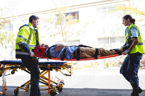 Ambulancemen carrying injured man on a stretcher