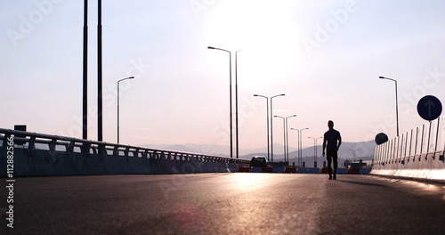 Silhouette of a fitness man profile stretching at sunset with th