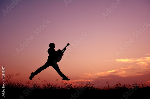 Silhouette man with guitar in the sunset