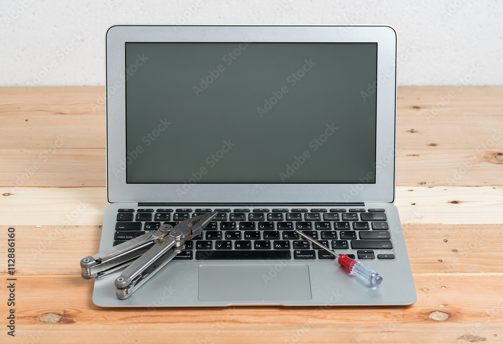 wrench tool and screwdrivers over a laptop, repair service concept
wrench tool and screwdrivers over a laptop, repair service concept