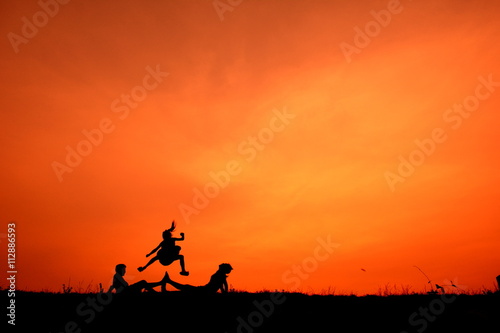 Silhouette of kids playing together at sunset