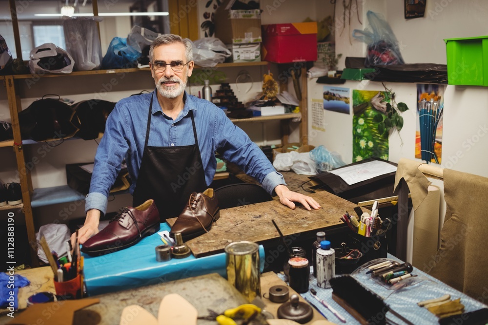 Portrait of smiling cobbler standing in workshop Portrait of smiling cobbler standing in workshop