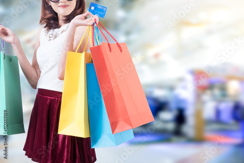 smiling young woman with happiness, credit card ,sale and people concept and shopping bags over mall background
