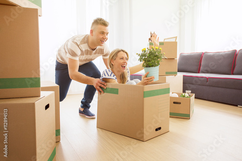 Funny couple having fun while moving into new apartment