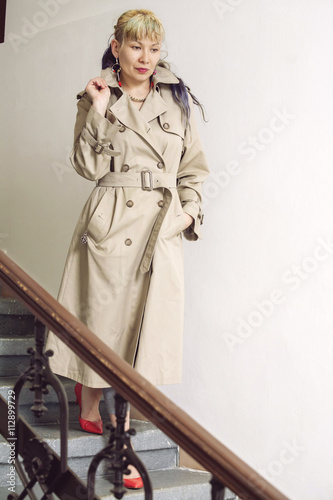 Woman on the stairs wearing beige trenchcoat
