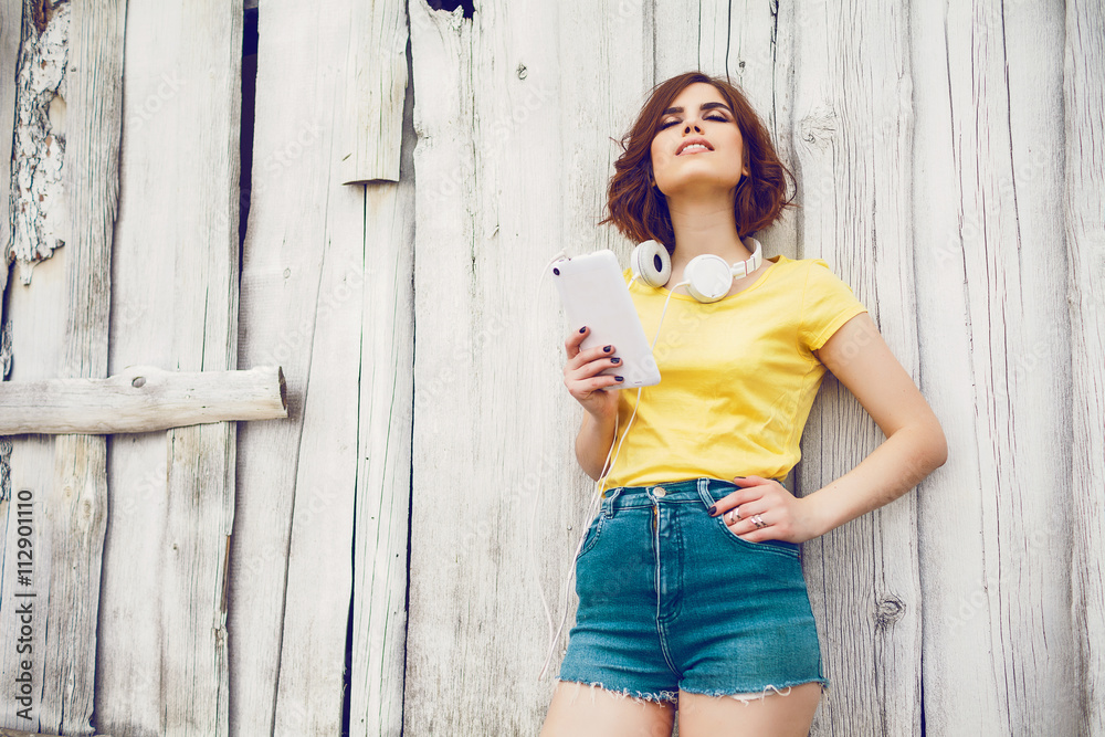 Fototapeta premium Funny Hipster Girl over white old wooden wall, hipster outfit Going Crazy at tropical island.Trendy Casual Fashion Outfit in summer,spring.Toned Photo,Copy Space.