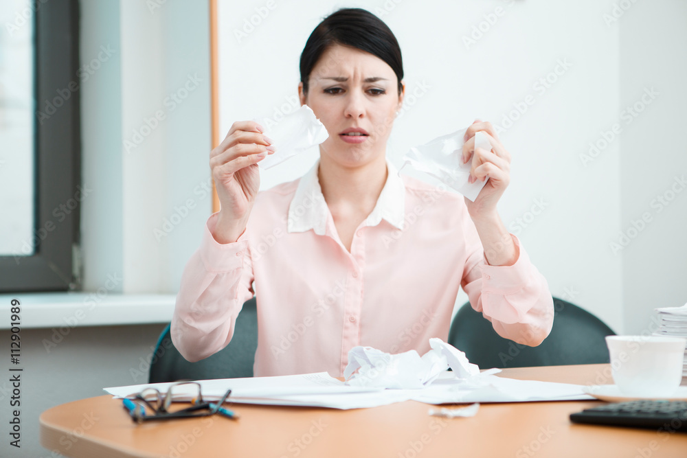 Woman in office with crumpled paper. Woman in office with crumpled paper.