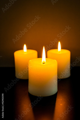 closeup to burning candles in darkness