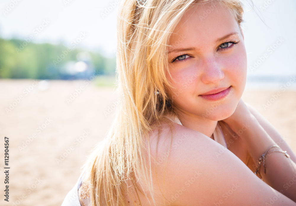 Sweet blonde young girl resting on a beach in a sunny morning Sweet blonde young girl resting on a beach in a sunny morning
