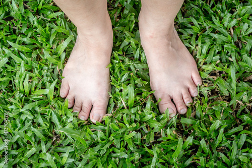 Female feet on green grass