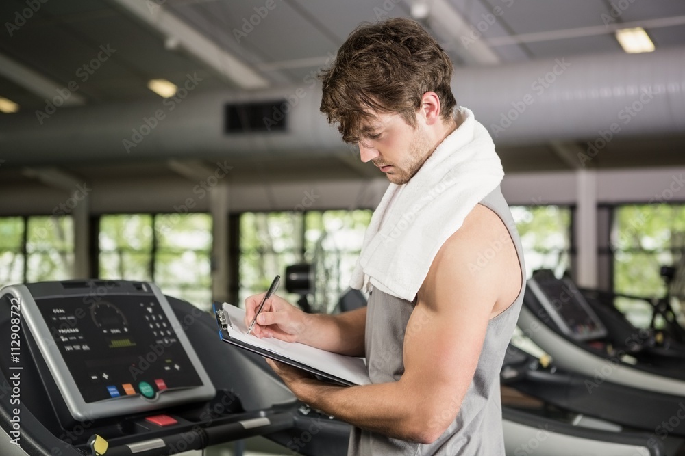 Gym instructor writing on clipboard Gym instructor writing on clipboard