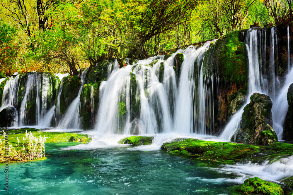 Amazing waterfall and azure lake with crystal clear water